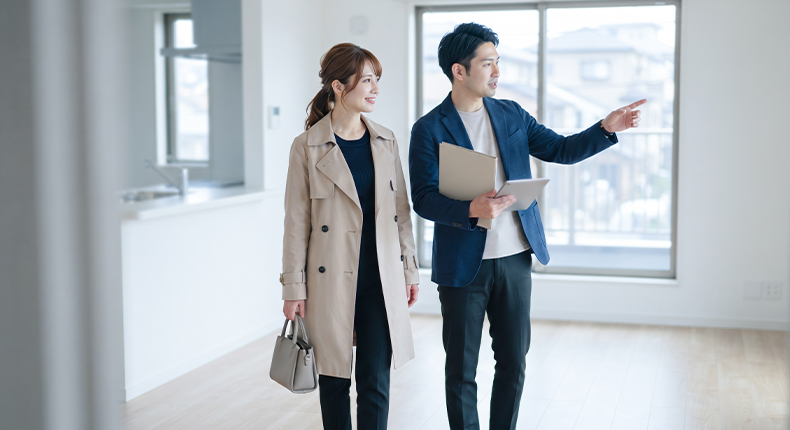 内見で部屋を案内する不動産会社の担当者と女性客